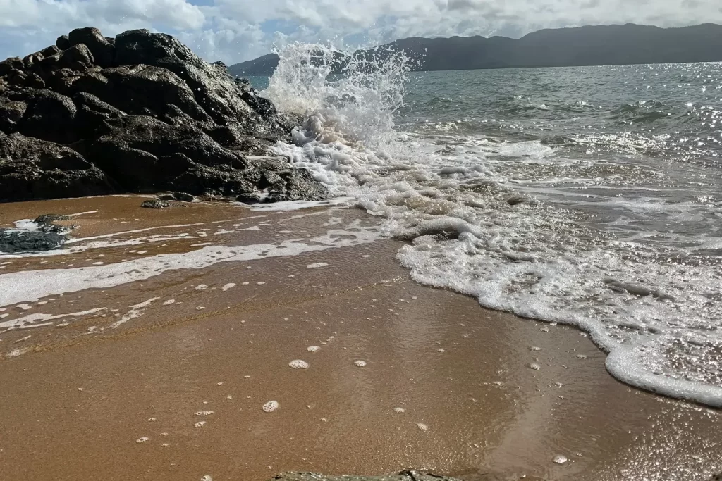 The sea waves crashing on a rock at Pallarenda Beach in Townsville, North Queensland