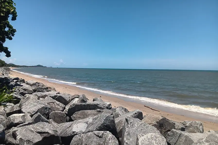 View of the rocks, sand and Coral Sea at Machans Beach in Tropical North Queensland