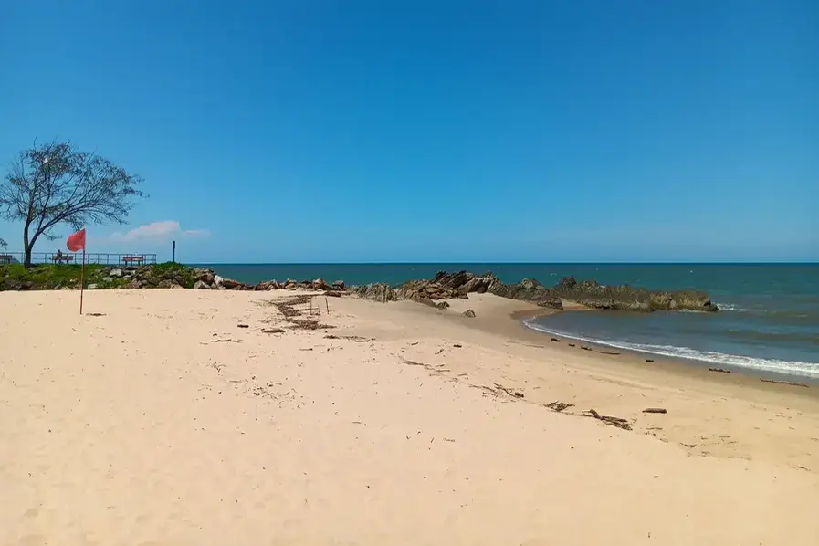 View of the sand and Coral Sea at one end of Yorkeys Beach in Tropical North Queensland